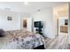 Open-concept main bedroom with wood-look floors, mounted TV, ensuite bathroom and closet access at 332 Blue Lake Cir, Kissimmee, FL 34758
