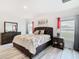 Bright main bedroom featuring a stylish headboard, bedside table, dresser and ensuite bath access at 332 Blue Lake Cir, Kissimmee, FL 34758