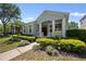 Inviting single-story home featuring a covered porch with white pillars, complemented by lush landscaping and mature trees at 336 Sunset Oaks Rd, Winter Garden, FL 34787
