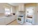 Traditional kitchen featuring white cabinets, tile floors, and an adjacent living area at 340 Zelda Blvd, Daytona Beach, FL 32118