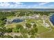 A serene aerial view of a park with water features, lush greenery, and clear blue skies with some cloud cover at 397 Shoreview Sands Ave, Mascotte, FL 34753