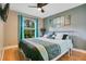This bedroom features a modern ceiling fan, hardwood floors, and a bright, arched window at 400 Shelby Ct, Apopka, FL 32712