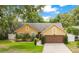 Beautifully landscaped house with a two-car garage, showcasing lush greenery and a well-maintained exterior at 400 Shelby Ct, Apopka, FL 32712