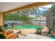 A screened in pool area with several chairs for lounging, greenery, and an attached hot tub at 400 Shelby Ct, Apopka, FL 32712