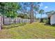 Expansive backyard with a wooden fence, mature trees, and a well-maintained lawn at 401 Sanford Ave, Longwood, FL 32750