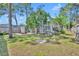 Spacious backyard with a lush lawn, mature trees, and a glimpse of the screened-in lanai at 401 Sanford Ave, Longwood, FL 32750