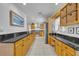 Expansive kitchen featuring ample wood cabinetry, black countertops, and modern stainless-steel appliances at 401 Sanford Ave, Longwood, FL 32750