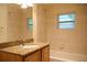 Tiled bathroom features a shower, bathtub, window, and vanity with granite countertop at 415 N Fern Creek Ave, Orlando, FL 32803