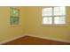 Bedroom with yellow walls, wood floors, and natural light from two windows at 415 N Fern Creek Ave, Orlando, FL 32803