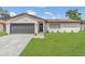 Charming white brick home featuring a well-manicured lawn, gray garage door, and inviting front entrance at 4636 Mesa Verde Dr, St Cloud, FL 34769