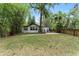 Quaint home exterior with lush green lawn, mature trees and landscaping, and lovely walkway to a cozy front porch at 506 S Hyer Ave, Orlando, FL 32801