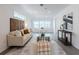 Cozy living room with a modern glass coffee table, neutral decor, and a view to the outdoor at 506 S Hyer Ave, Orlando, FL 32801