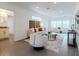 Open-concept living room with large windows, neutral furniture, and an adjacent bathroom with a granite vanity at 506 S Hyer Ave, Orlando, FL 32801