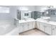 Bright bathroom featuring a large mirror over a double vanity and a separate soaking tub at 509 New Providence, Davenport, FL 33897