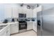 Well-lit kitchen with white cabinets, stainless steel appliances, and hardwood floors at 509 New Providence, Davenport, FL 33897