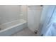 Bright bathroom featuring a bathtub with white tile surround and neutral flooring at 516 Madison Dr, Davenport, FL 33837