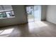 Neutral living area bathed in natural light, complete with tiled floors and sliding glass door at 516 Madison Dr, Davenport, FL 33837