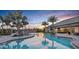 Community pool featuring ample seating, palm trees, and a cozy fireplace at sunset at 5333 Spoonflower Ct, St Cloud, FL 34771
