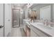 Bright bathroom with dual sinks, quartz counters, modern fixtures, and a glass-enclosed shower at 5337 Spoonflower Ct, St Cloud, FL 34771