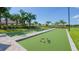 Recreational bocce ball court with well-maintained green turf, palm trees, and shaded seating at 5337 Spoonflower Ct, St Cloud, FL 34771