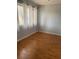 Small bedroom with laminate floors and a window with white curtains at 5926 Peregrine Ave # A13, Orlando, FL 32819