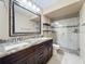 Renovated bathroom featuring double sinks, granite countertops, and glass-enclosed shower at 6 Escondido Cir # 64, Altamonte Springs, FL 32701