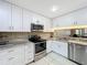 Well-appointed kitchen with stainless steel appliances, stone backsplash, and white cabinetry at 6 Escondido Cir # 64, Altamonte Springs, FL 32701