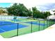 View of multiple tennis courts surrounded by mature trees and fencing in a well-maintained community at 6 Escondido Cir # 64, Altamonte Springs, FL 32701