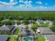 An aerial view showcases a home with solar panels and a screened-in pool within a lush community at 610 Carey Way, Orlando, FL 32825