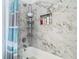 Marble tiled tub and shower area featuring a recessed shelf for toiletries and a stylish shower curtain at 610 Carey Way, Orlando, FL 32825