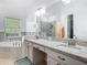 Dual sink vanity area with granite countertops and a separate tub and shower area at 610 Carey Way, Orlando, FL 32825