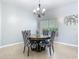 Cozy dining area featuring a round table, upholstered chairs, a chandelier and natural light from the window at 610 Carey Way, Orlando, FL 32825