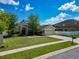 Inviting one-story home featuring a manicured lawn, lush landscaping, and an attached two-car garage at 610 Carey Way, Orlando, FL 32825