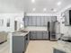Open kitchen featuring gray cabinets, granite countertops, and stainless steel appliances at 610 Carey Way, Orlando, FL 32825