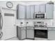 Modern kitchen featuring stainless steel oven, cooktop, microwave and gray cabinets at 610 Carey Way, Orlando, FL 32825