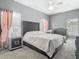 This main bedroom boasts plush carpeting, a gray headboard and includes a tray ceiling with a ceiling fan at 610 Carey Way, Orlando, FL 32825