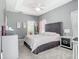 This main bedroom boasts plush carpeting, a gray headboard and includes a tray ceiling with access to the bathroom at 610 Carey Way, Orlando, FL 32825