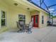 Covered lanai with outdoor dining, barbecue grill and red-framed doors looking into the home at 610 Carey Way, Orlando, FL 32825