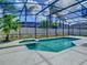 A beautiful backyard featuring a screened-in pool and spa surrounded by lush tropical landscaping at 610 Carey Way, Orlando, FL 32825
