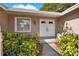 Inviting front entrance with white double doors, complemented by lush landscaping and a bright window at 650 Sweetbriar Br, Longwood, FL 32750