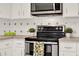 Modern kitchen with sleek stainless steel oven and countertop with plants at 650 Sweetbriar Br, Longwood, FL 32750