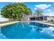 Backyard pool with screened in patio, grassy area and privacy fence under blue skies at 650 Sweetbriar Br, Longwood, FL 32750