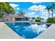 Sparkling backyard pool with a large screened patio and grass lawn under blue skies at 650 Sweetbriar Br, Longwood, FL 32750