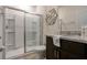 Bathroom boasts a glass door shower, granite countertop, mirror, and decorative wall art at 7618 Oakmoss Loop, Davenport, FL 33837