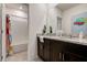 Bathroom with double sinks, granite countertops, a mirror, decorative plants, and a bathtub at 7618 Oakmoss Loop, Davenport, FL 33837