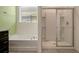 Bright bathroom with a tub and shower combo, plus modern fixtures and finishes at 7618 Oakmoss Loop, Davenport, FL 33837