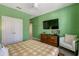 Bright bedroom features a ceiling fan, television, and dresser with fish decoration on the top at 7618 Oakmoss Loop, Davenport, FL 33837