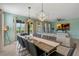 Combined dining and living area with a large table, ample seating, and natural light for gatherings at 7618 Oakmoss Loop, Davenport, FL 33837