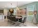 Stylish dining area with a modern light fixture, seating for eight, and neutral decor, perfect for entertaining at 7618 Oakmoss Loop, Davenport, FL 33837