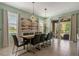 Elegant dining room with a large table, modern light fixtures, and sliding doors leading to outdoor space at 7618 Oakmoss Loop, Davenport, FL 33837